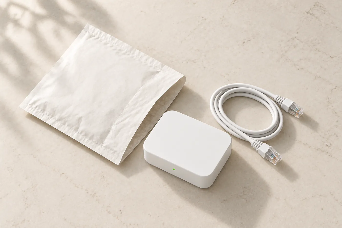 Everything that comes in the post, laid out on a kitchen counter: a slim padded envelope, the box, and one coiled network cable.